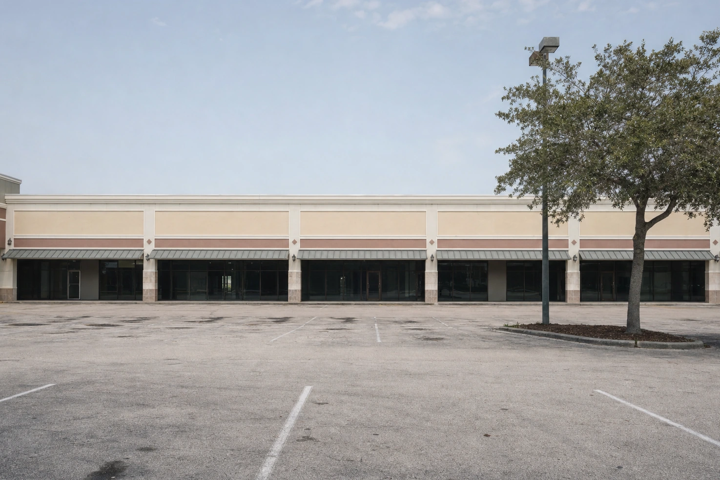 A commercial strip we photographed frontally at midday — single-storey units, blank fascias with no lettering, a wide apron of asphalt in front.