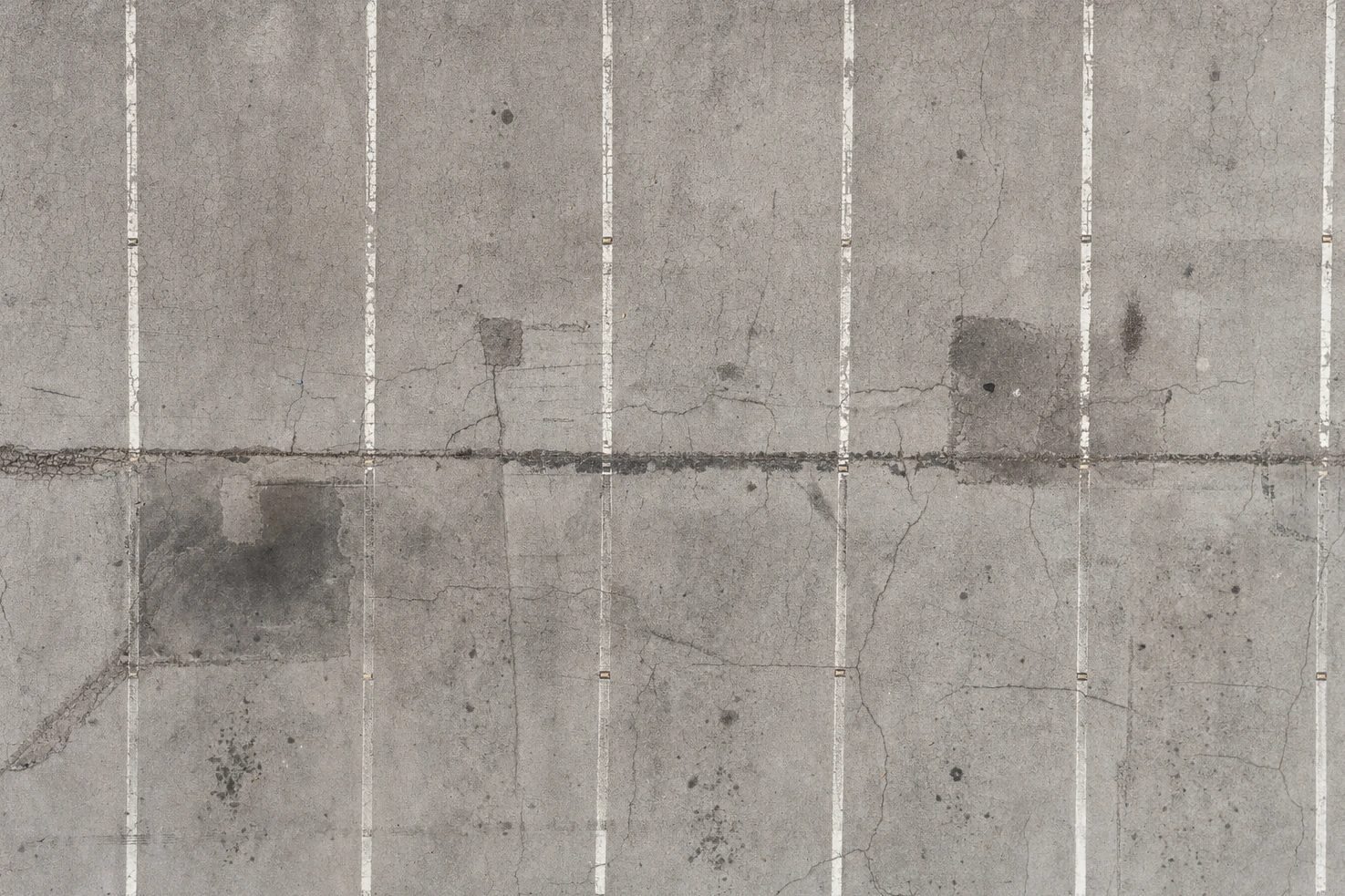 Our picture of worn asphalt with faded lane markings, taken from directly above in flat light.