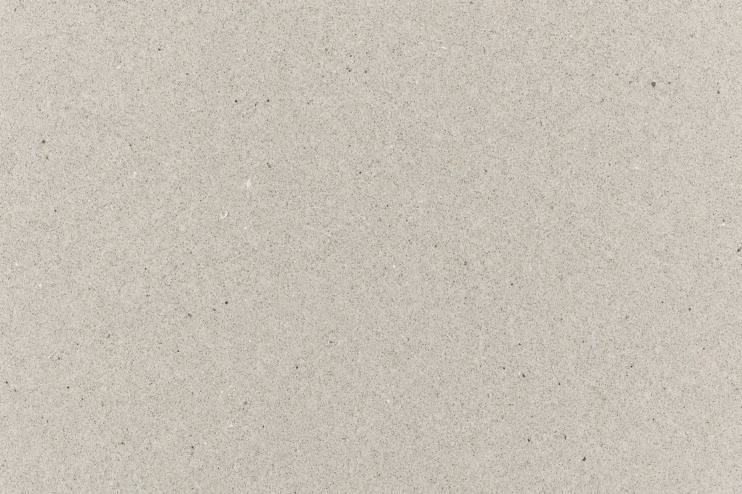 Clean pale sand filling the entire frame, photographed by us from directly above at midday.